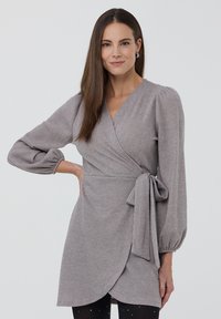 Abito avvolgente grigio con maniche lunghe a sbuffo, cintura in vita e tessuto strutturato con una sottile lucentezza. Design liscio, lungo fino al ginocchio.