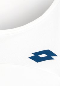 Valge sporditop, millel on tekstuuriga kangas ja tumesinine logo aktsent, esitleb ümmargust kaelaava ja puhtaid lõikeäärte.