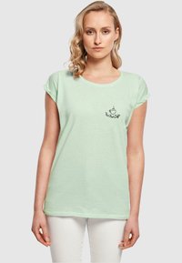Minzgrünes kurzärmliges T-Shirt aus weicher Baumwolle, mit einem kleinen Kaffeetassen-Graphic und Text auf der linken Brustseite.