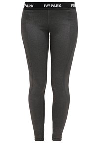 Ivy Park leggings i mörkgrått tyg med en figursydd design. Funktioner inkluderar en svart midja med vit logotyptext och subtil sömnadsdetaljer.