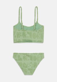 Groene badmode set van terry stof bestaande uit een cropped top met verstelbare bandjes en een bijpassende bikini onderkant, beide versierd met textuurpatronen van bloemen.