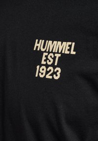 Zwarte T-shirt van katoen met crèmekleurige tekst: "HUMMEL EST 1923" prominent weergegeven op de voorkant.