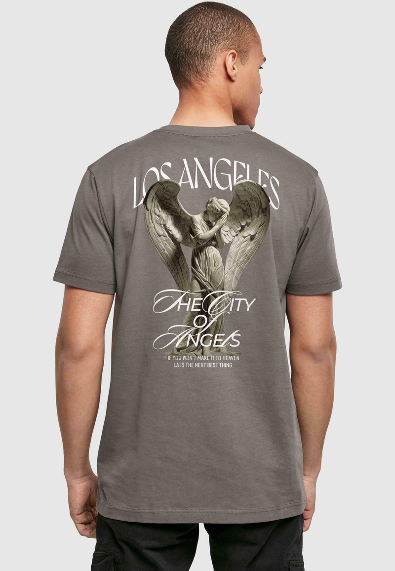 Siv grafični majica z velikim dizajnom angela na hrbtni strani, s tiskanimi besedami "Los Angeles" in "Mesto angelov" nad in pod.