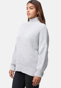 Jasnoszary sweter dzianinowy z wysokim kołnierzem, prążkowanym wykończeniem i szerokimi rękawami. Teksturowana tkanina o luźnym, wygodnym kroju.