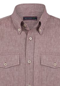 Camisa de color púrpura claro, de botones y confeccionada con una tela texturada. Cuenta con un cuello extendido, un bolsillo en el pecho y acentos de botón en blanco.