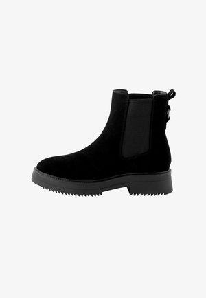 Fekete velúr Chelsea csizmák, elasztikus oldalsó panelekkel, texturált fekete gumitalppal és húzófüllel a saroknál. Masszív, boka magasságú dizájn.