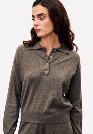 Donkergrijze gebreide pullover met een kraag, lange mouwen en een vierknops sluiting. Zachte textuur met een aansluitende tailleband en een subtiele glans.