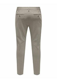 Pantalones beige de corte ajustado, con dos bolsillos traseros y tejido elástico sutil para mayor comodidad. Textura suave y líneas limpias.