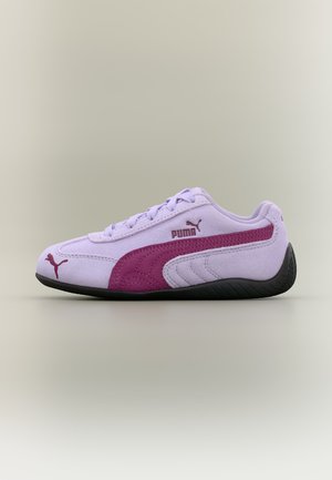 Baskets Puma lavande avec une bande rose foncé, logo Puma sur le côté et à l'avant, coutures blanches, semelle noire, présentées sur un fond neutre.