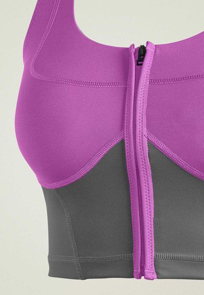 Purple zip-up sports bra featuring a two-tone design with a smooth texture, contrasting gray bottom, and visible stitching details.