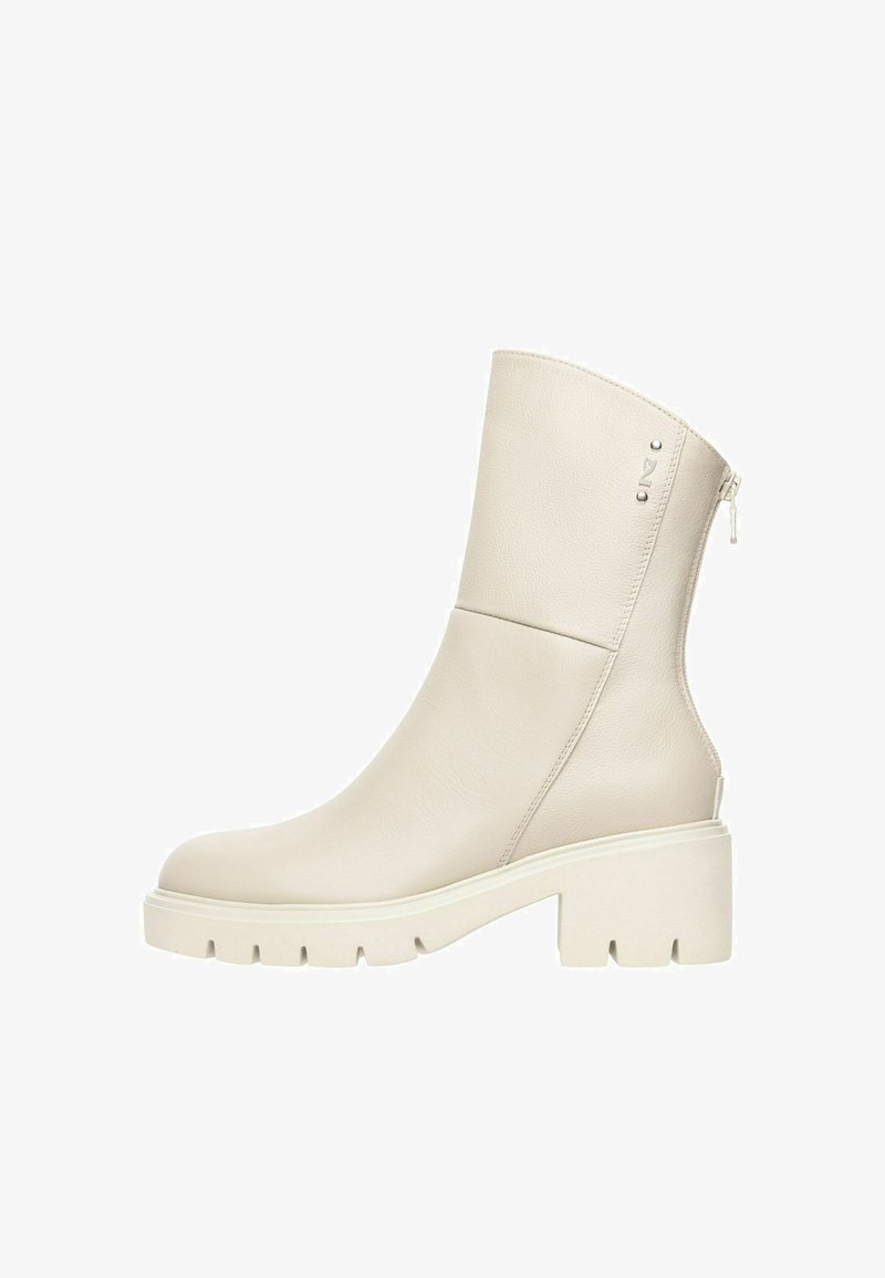 Bottes en cuir blanc cassé mi-mollet avec semelle épaisse, talon bloc, fermeture éclair latérale et petit logo métallique près du bord supérieur.