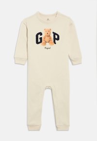 Béžové bavlnené body s dlhými rukávmi, so vyšívaným medveďom a nápisom "GAP" v námorníckej modrej. Zapínanie na gombíky na ramene, elastické manžety.