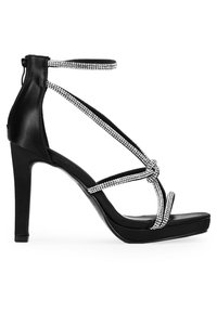 Sandalía negra de tacón alto con plataforma, que presenta tiras brillantes de rhinestones y una correa para el tobillo, textura de cuero suave y diseño elegante.