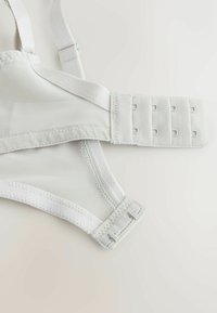 Hvid bh med mesh og fast stof, justerbare stropper og lukning med krog og øje med fire indstillinger til størrelsesjustering.