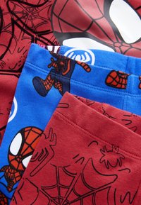 Tissu rouge et bleu avec des motifs de Spider-Man, incluant des motifs de toile et des visages de Spider-Man, qui se chevauchent en gros plan.