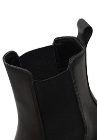 Stivaletto nero con pelle liscia e pannelli elastici laterali. Presenta una punta arrotondata e una linguetta per un facile utilizzo.