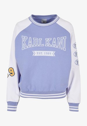 Vijoličen pulover s toplimi belimi raglan rokavi, ki vsebuje 'KARL KANI EST. 1989' v belih in rumenih poudarkih, z rebrastim ovratnikom in robom.