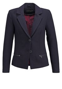 Granatowa marynarka o dopasowanym kroju, z przodem na dwa guziki i zamkami błyskawicznymi w kieszeniach. Wnętrze podszewki w kolorze burgundowym z subtelnymi wzorami.