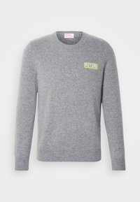 Pilkas megztinis su apvalia iškirpte. Ant krūtinės yra mažas žalias "FUTURE" logotipas. Riebūs rankogaliai ir apvadas, minkšta tekstūra.