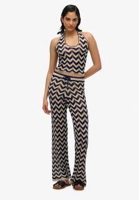 Halternekk crop top en wijde broek set in marineblauw en crèmewitte zigzagpatroon, met een trekkoord in de taille en een lichte, gestructureerde stof.