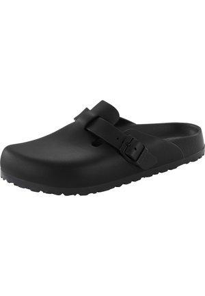 Schwarzer Slip-On-Clog mit verstellbarem Schnallenriemen und strukturiertem Sohlenprofil, konzipiert für den lässigen oder Indoor-Gebrauch.