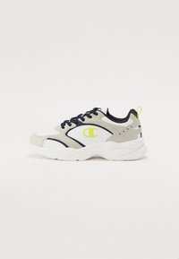 Valged, hallid ja tummsinised tenis kingad, millel on paks disain, tekstuuriga paneelid ja kollane logo aktsent külgedel.