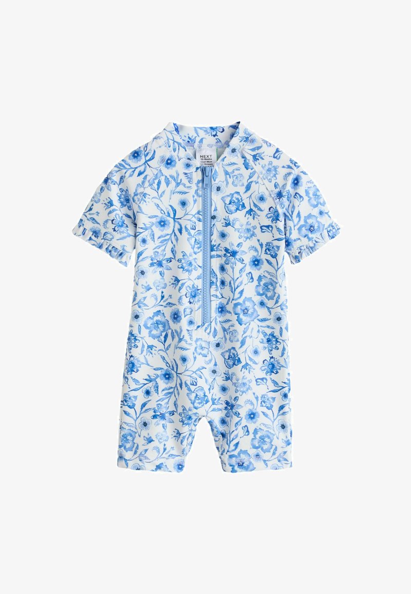 Hvid baby shortærmet heldragt med blå blomstermønster og lynlås foran, størrelse 12-18 måneder, uden krave.