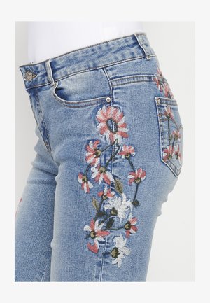 Jeans din denim albastru cu broderie florală în nuanțe de roz și alb pe lateral și pe buzunarele din spate, cu un design clasic cu cinci buzunare.