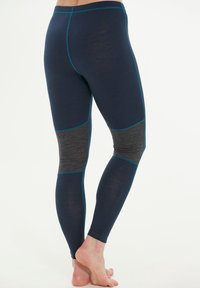 Marina blå leggings med grå detaljer och turkos sömnad. Mjukt tyg, figurnära design, med knäpatchar och hög midja.