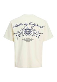 Creme t-shirt med et navy blåt blomsterdesign på ryggen, med teksten "Studio by Originals" ovenfor og en afslappet pasform. Materiale af bomuld.