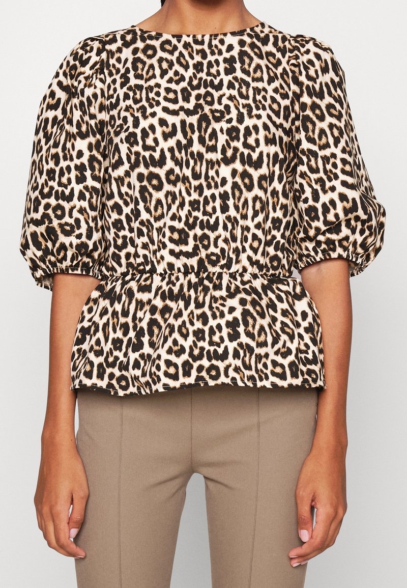Leopardmönstrad blus med rund halsringning, puffärmar och midjedetalj med volang, tillverkad av ett lätt tyg.