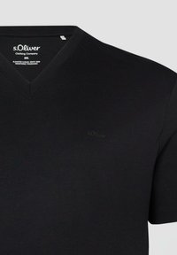 T-shirt noir à col en V s.Oliver en taille 2XL, avec un logo discret sur la poitrine et une étiquette de marque imprimée à l'intérieur du col.