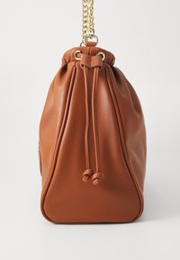 Rjava usnjena torba z vrvico, z zlatim verižnim ročajem in zloženim vrhom. Gladka tekstura, okrogla osnove in dve poudarjeni vrvici.