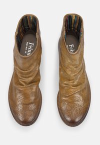 Bottines en cuir marron avec motif perforé, design flou et doublure intérieure rayée multicolore. Semelle plate, bout arrondi.