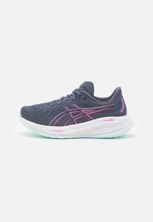 Laufschuhe aus dunkelblauem Mesh mit pinken Akzenten. Verfügt über eine weiße Zwischensohle, strukturierten Oberflächen und einer grünen Sohle. Sauberes, modernes Design.