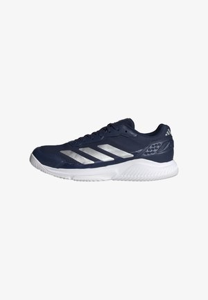 Zapatilla deportiva de la marina con rayas plateadas, parte superior de malla para transpirabilidad y suela de goma. Cuenta con un collarín acolchado y soporte texturizado en el talón.