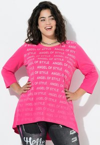 Maglietta a maniche lunghe rosa con motivo testuale "ANGEL OF STYLE". Collo rotondo, vestibilità comoda e orlo curvo. Abbinata a jeans scuri strappati.