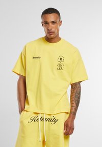 Yellow cotton T-shirt with short sleeves. Features "Reternity" logo and number "18" printed on the front, relaxed fit, soft texture.