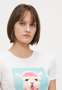 T-shirt en coton blanc avec un graphique coloré d'alpaga centré à l'avant, à manches courtes et col rond classique.