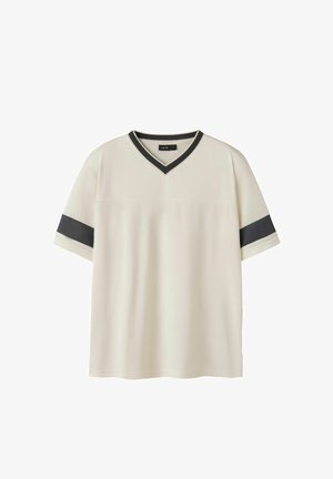 Cremefarbenes T-Shirt mit kurzen Ärmeln, schwarzem V-Ausschnitt und schwarzen horizontalen Streifen an jedem Ärmel.