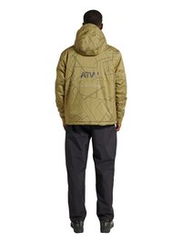 Mann trägt eine olivgrüne Kapuzenjacke mit Kartenmuster und dem Schriftzug "ATW" auf dem Rücken, schwarze Hose und dunkle Wanderschuhe, steht mit dem Rücken zur Kamera.