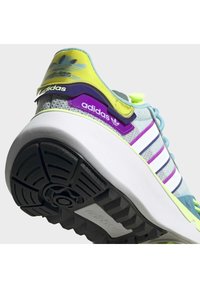 Sport shoes featuring a pastel blue upper with purple and yellow accents, white stripes, and a black textured rubber outsole.