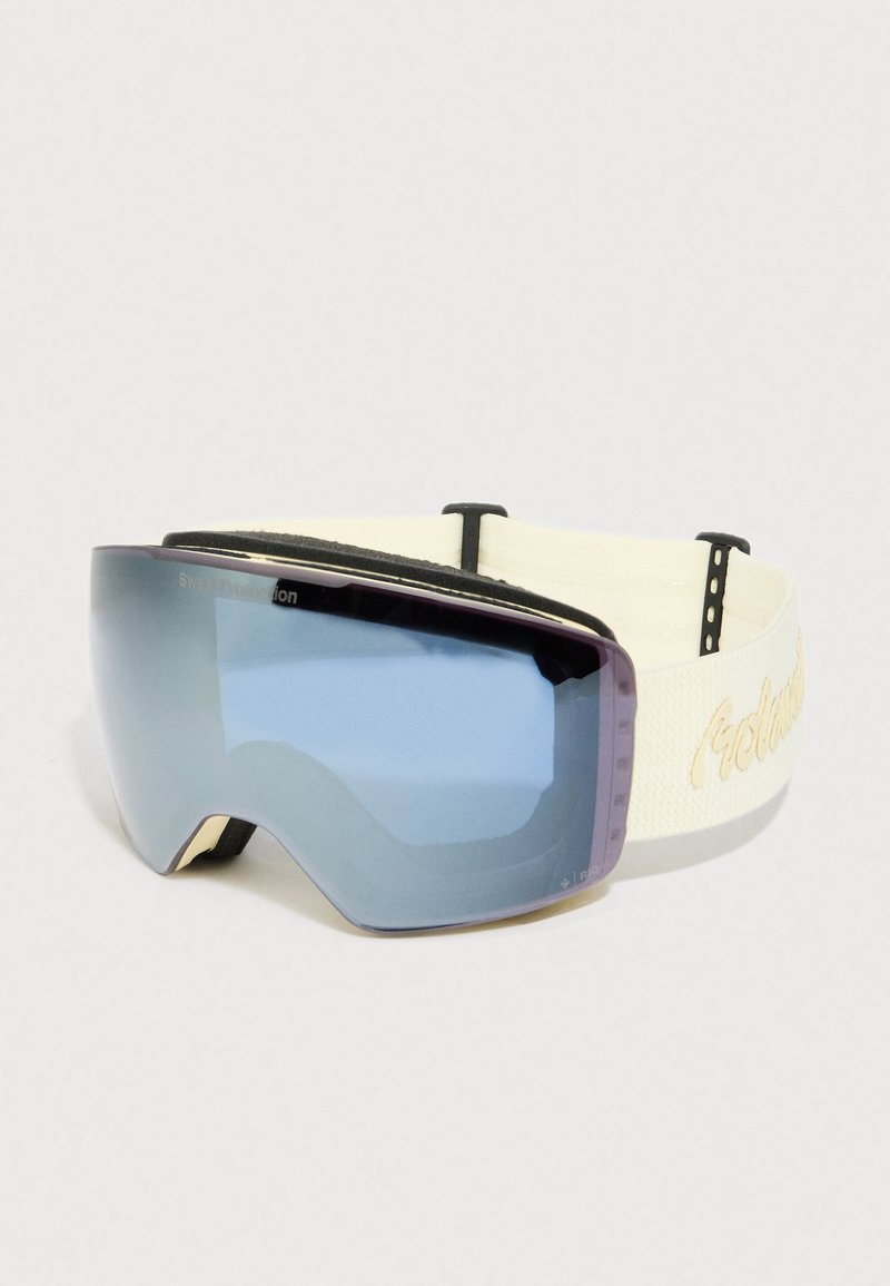 Óculos de esqui com lentes azuis espelhadas e correia bege ajustável com texto bordado, sobre um fundo branco liso.