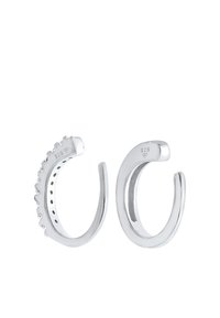 Orecchini in argento con un design curvo, uno presenta accenti appuntiti e l'altro è liscio. Marcati con "925" per la qualità dell'argento sterling.