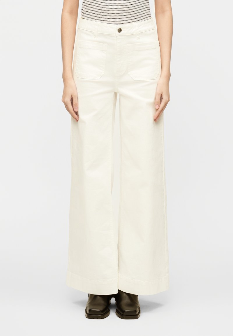 Pantalon blanc à jambes larges en coton, avec une taille haute, deux poches avant et une fermeture à bouton. Lignes épurées et texture lisse.