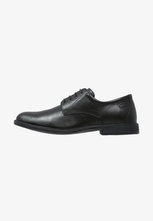 Chaussure habillée pour homme en cuir noir avec fermeture à lacets et un petit talon empilé, vue de profil sur fond blanc.