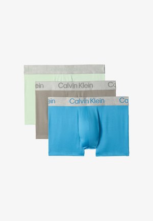 Drie herenboxers van Calvin Klein in blauw, grijs en lichtgroen met zilverkleurige, merkgebonden taillebanden, overlappend gerangschikt op een witte achtergrond.