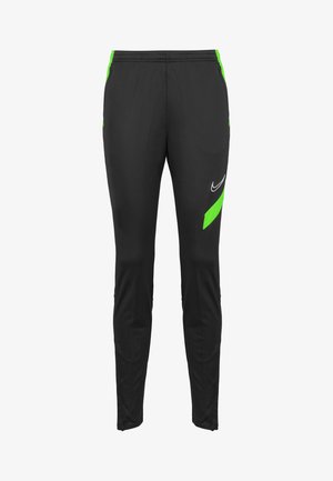 Pantalones de chándal Nike en negro con acentos verdes. Cuentan con una cinturilla elástica, bolsillos laterales y un logo en el muslo. Textura suave y corte ajustado.
