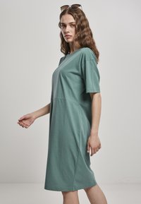 Mint zelena oversized majica haljina od mekanog pamuka, s kratkim rukavima, bočnim šavovima i opuštenim siluetom.