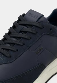 Ναυτικά δερμάτινα αθλητικά παπούτσια με υφή, επίπεδες κορδόνια και λευκή λαστιχένια σόλα. Διαθέτουν ανάγλυφο λογότυπο «BOSS» στη γλώσσα και στο πλάι.